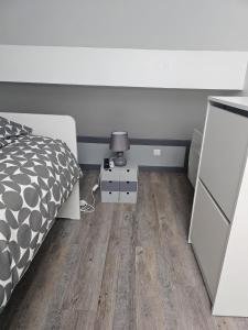 ein Schlafzimmer mit einem Bett und einer Lampe auf einem Holzboden in der Unterkunft Blue Baroque Rer-C N104-A6 in Brétigny-sur-Orge