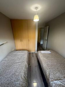 a bedroom with two beds and a light fixture at Iacomm Newbridge 2 bed apt in Newbridge