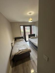 a room with two beds in it with a window at Iacomm Newbridge 2 bed apt in Newbridge