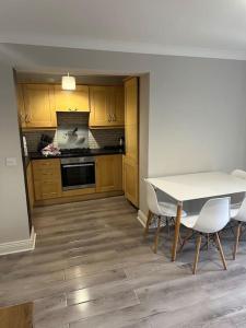 eine Küche mit einem Tisch und Stühlen im Zimmer in der Unterkunft Iacomm Newbridge 2 bed apt in Newbridge