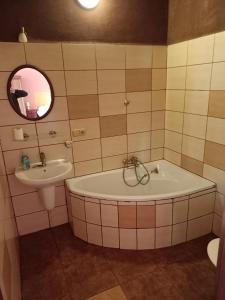 y baño con bañera y lavamanos. en Penzion U strhaného klempíře, en Ropice