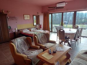 a living room with a table and chairs and a dining room at Penzion U strhaného klempíře in Ropice
