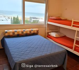 a bedroom with two bunk beds and a window at Apartamento com vista para o mar in Torres