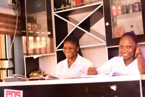 two chefs sitting at a counter in a restaurant at Royal Suites And Apartments Lugbe, Abuja 