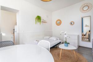 a small white room with a bed and a table at Cosy apartment in the heart of Marseille - Welkeys in Marseille