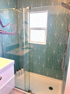 a shower with a glass door in a bathroom at Casa California - Backyard, BBQ, Firepit & Near Beaches in San Diego +24 photos