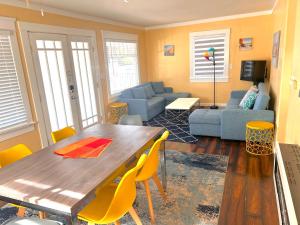 een woonkamer met een houten tafel en gele stoelen bij Casa California in San Diego