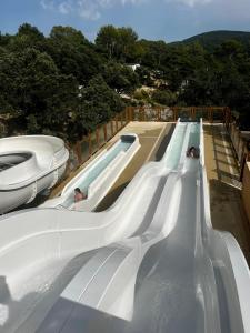 eine Wasserrutsche mit zwei Personen, die darauf reiten in der Unterkunft Mobil-home dans camping 4* in Saint-Laurent-du-Verdon