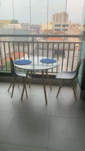 einen Tisch und zwei Stühle auf dem Balkon in der Unterkunft Elegance Suítes Anhembi in São Paulo