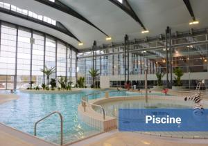a large indoor swimming pool in a building at Le Manhattan Proche Roissy CDG - Paris - Astérix in Moussy-le-Vieux