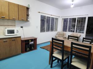 a kitchen with a table and chairs and a microwave at LUNA in Comodoro Rivadavia