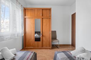a bedroom with a wooden door and a chair at Holiday home Sofia with private pool and stunning view of the sea in Kastel Novi +21 photos