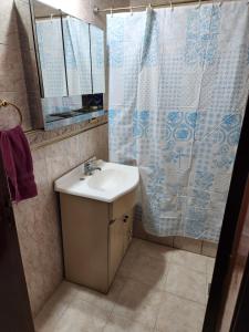 a bathroom with a sink and a shower curtain at LUNA in Comodoro Rivadavia +21 photos