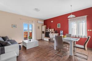 a living room with red walls and a table and chairs at Holiday home Sofia with private pool and stunning view of the sea in Kastel Novi