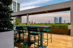 a table and chairs on a balcony with a view of the city at Lumina at Taman Condesa in Mexico City