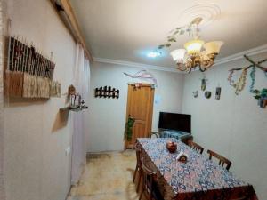 a dining room with a table and a chandelier at Sweet Home Hostel in Baku