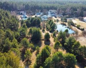an aerial view of a house and a lake at Agroturystyka Leśna Malinka in Celejów