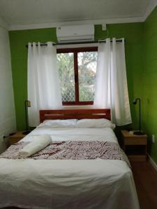 una camera da letto con un grande letto e una finestra di Fale Mailani-2 rooms/AC/hotwater a Vaitele