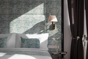 1 dormitorio con 1 cama con una pared verde y gris en Sanasaryan Han, a Luxury Collection Hotel, Istanbul en Estambul