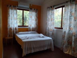 a bedroom with a bed and two windows at Fale Mailani-2 rooms/AC/hotwater in Vaitele