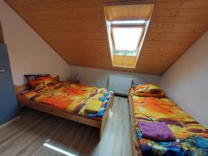 2 łóżka pojedyncze w pokoju z oknem w obiekcie Agroturystyka Leśna Malinka 