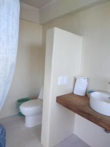 a bathroom with a toilet and a sink at Villas Roberto's Bistro Mirador in Troncones