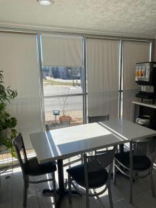 a table and chairs in a room with a window at Howard Johnson by Wyndham Historic Lake Charles in Lake Charles