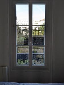 ein Schlafzimmerfenster mit Blick auf einen Balkon in der Unterkunft Appartement 2 pièces proche de Paris in Charenton-le-Pont