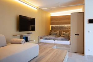 a living room with a couch and a flat screen tv at Finy Homes Stegersbach in Stegersbach