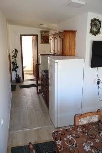 a kitchen with a white refrigerator and a table at Odmor u Komaranima in Nova Varoš