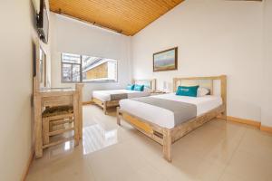 een slaapkamer met 2 bedden en een raam bij Hotel Ana Carolina in Manizales