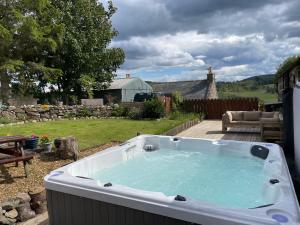 a large hot tub in a yard with a patio at Barclay’s But n Ben in Alford