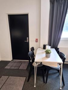 Zimmer mit einem Tisch und Stühlen sowie einer schwarzen Tür in der Unterkunft Rentalux Apartments at Vivansborg in Timrå