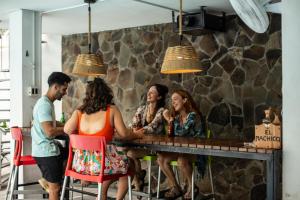 a group of people sitting at a bar at El Machico Hostel in Panama City