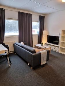 a living room with a blue couch and a television at Rentalux Apartments at Vivansborg in Timrå