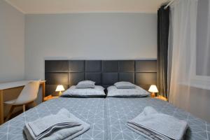 um quarto com uma cama grande e toalhas em Apartament Dzień Dobry 3 em Wałbrzych
