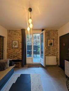 ein Wohnzimmer mit einem Sofa und einer Glastür in der Unterkunft Apartment with terrace for 2 to 4 people in Boulogne-Billancourt