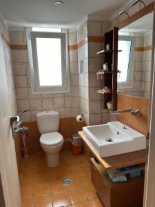 a bathroom with a toilet and a sink at ΔΩΜΑΤΙΟ ΧΑΛΑΡΩΣΗΣ ΜΕ θέα και ησυχία in Patra