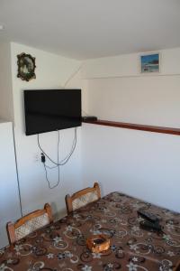 a room with a table and a television on a wall at Odmor u Komaranima in Nova Varoš