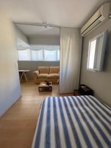 ein Schlafzimmer mit einem Bett und einer Couch in einem Zimmer in der Unterkunft Departamento Facultades in Buenos Aires + 7 Fotos