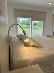 a bedroom with a bed with a pillow and a window at La Jacinta posada suites in Santa Rosa de Calamuchita