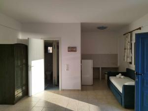 a bedroom with a bed and a room with a refrigerator at Ο Μήλας in Agios Dimitrios +121 photos