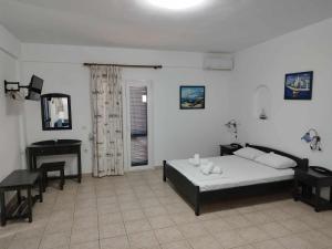 a bedroom with a bed and a desk in it at Ο Μήλας in Agios Dimitrios