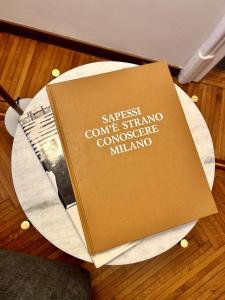 um livro sentado em cima de uma mesa em Fifty Eight Suite Milan em Milão