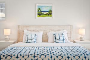 a white bedroom with a bed with blue and white pillows at Belmont Oasis I Downtown Cville in Charlottesville