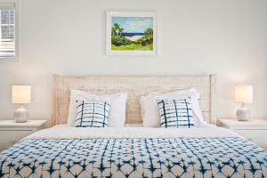una camera da letto bianca con un letto con cuscini blu e bianchi di Belmont Oasis I Downtown Cville a Charlottesville