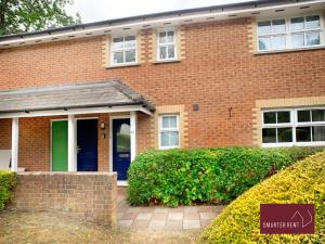 uma casa de tijolos com uma porta azul e verde em Wokingham - 2 Bedroom Maisonette - With Parking em Wokingham