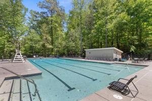 a large swimming pool with chairs and trees at Excellent Roswell Location! in Roswell