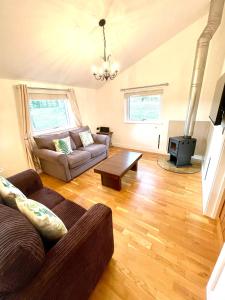 a living room with a couch and a stove at The Applewood Lodge in Heytesbury