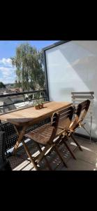 drewniany stół i 2 krzesła na balkonie w obiekcie Appartement 4 personnes idéal JO 2024 w mieście Tremblay-en-France